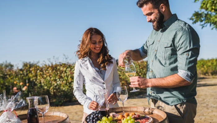Couple eating and drinking wine in vineyard